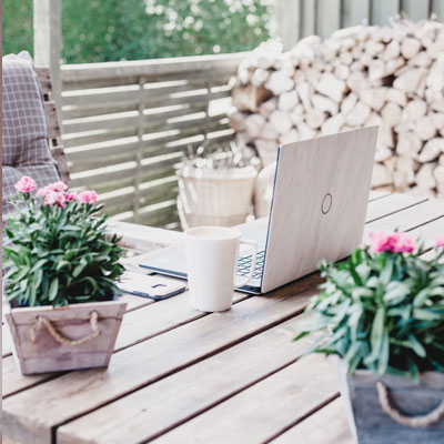 A wooden table with two potted plants and a laptop.