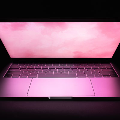 A pink laptop with the keyboard lit up.