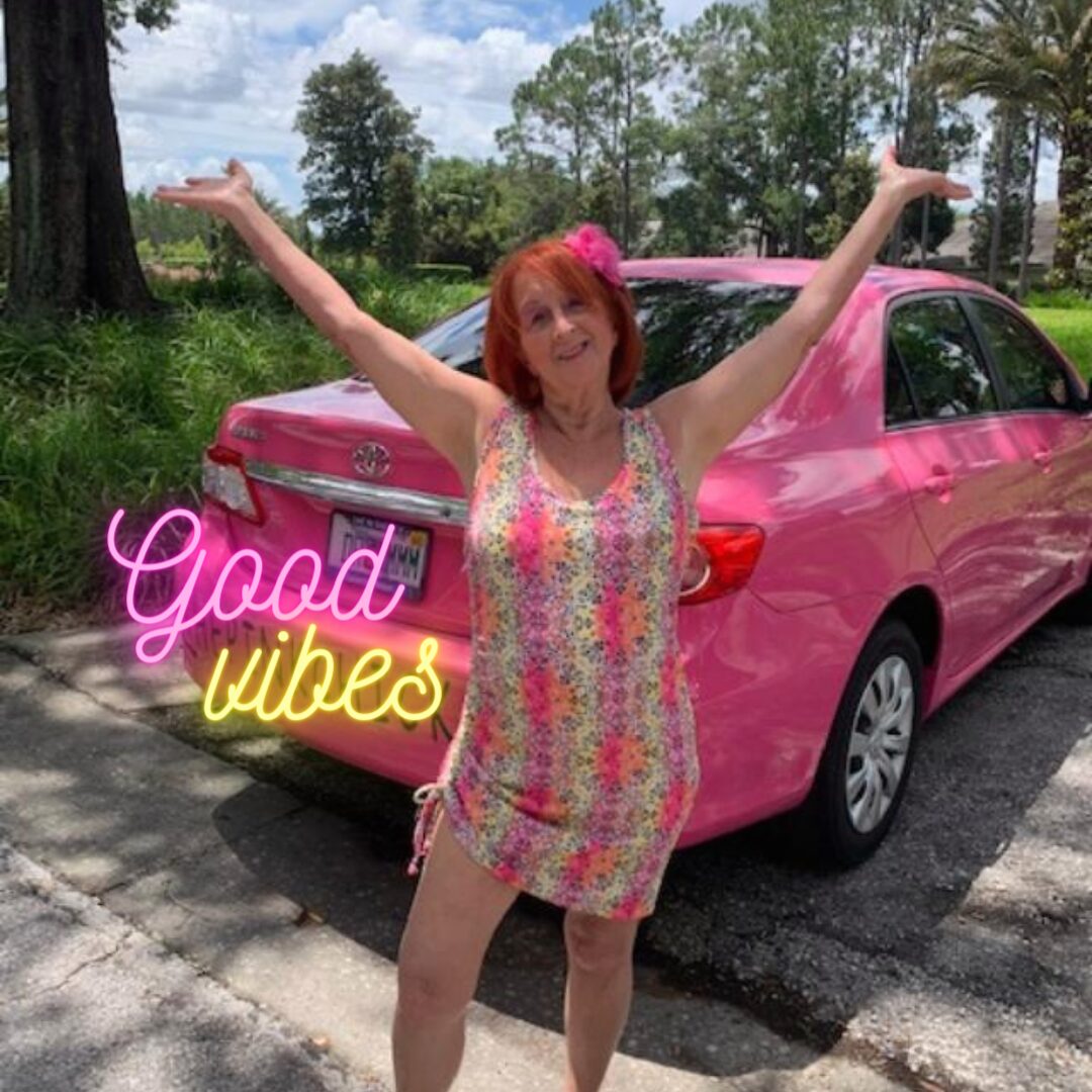 Linda Kaye, Pink Chick Psychic standing by her hot pink car. She created the Soul Mates And Love Vibes Song, and then went to songer.co, and had it put to music.